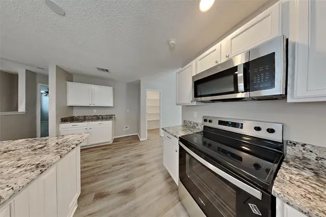 a kitchen with stainless steel appliances kitchen island wooden cabinets and granite counter tops