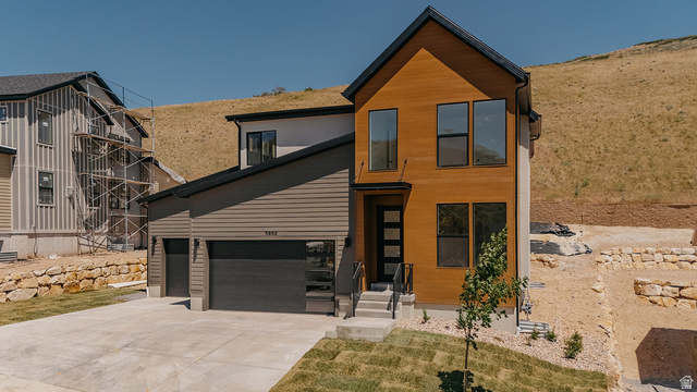 Modern two-story residence featuring a wood-finish facade and dark trim