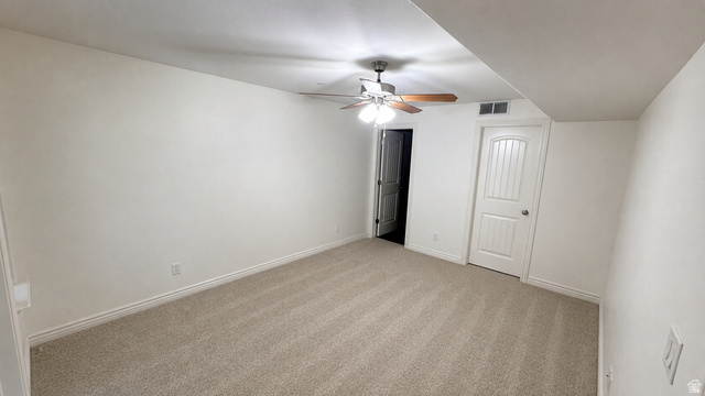 909 South Main Street, Unit F Layton, UT 84041 - Photo 10 of 21 Spacious room featuring neutral carpeting, white baseboards, and a ceiling fan with wood-finish blades