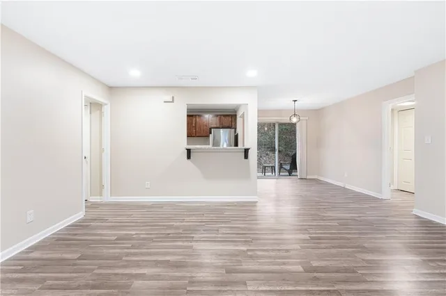 a view of a big room with wooden floor and windows