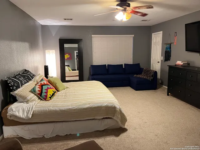 a bedroom with a bed dresser and a chandelier