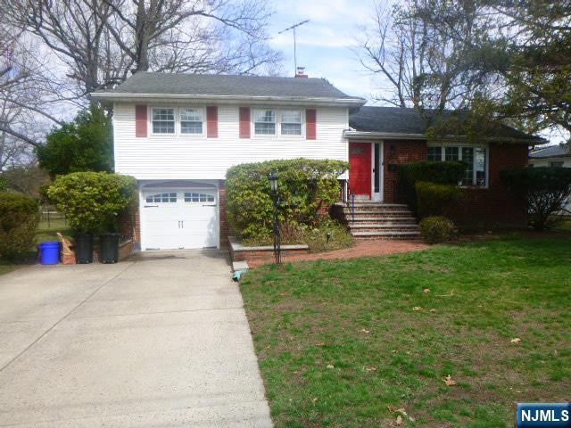 a front view of a house with a yard and a garage
