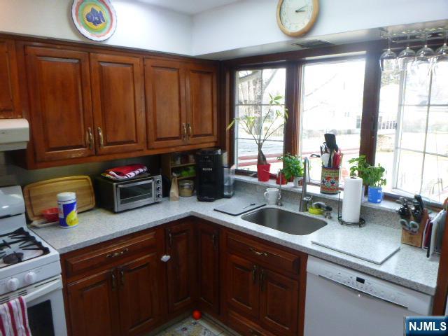 249 Madison Avenue Cresskill, NJ 07626 - Photo 11 of 26 a kitchen with sink cabinets and a large window