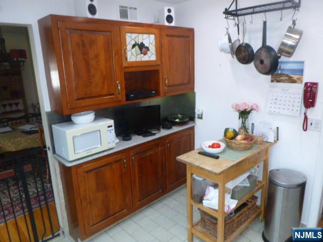 249 Madison Avenue Cresskill, NJ 07626 - Photo 7 of 26 a kitchen with stainless steel appliances a stove a microwave a refrigerator and cabinets
