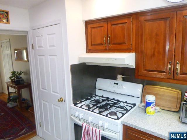 249 Madison Avenue Cresskill, NJ 07626 - Photo 9 of 26 a kitchen with a stove and wooden cabinets