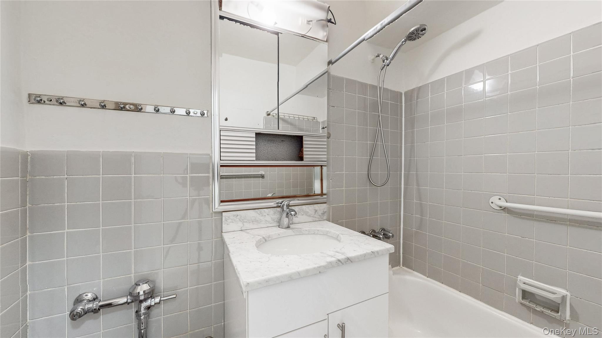 99-35 59th Avenue, Unit 4E Queens, NY 11368 - Photo 14 of 22 Bathroom with washtub / shower combination, vanity, and tile walls