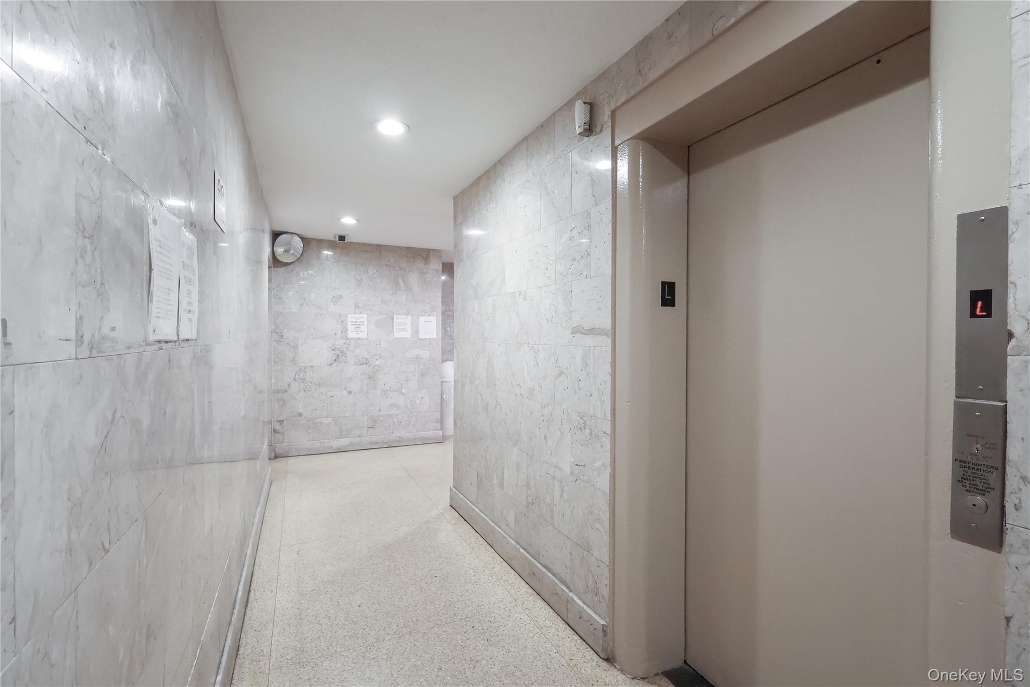 99-35 59th Avenue, Unit 4E Queens, NY 11368 - Photo 17 of 22 Hallway featuring elevator, speckle patterned floor, tile walls, and recessed lighting