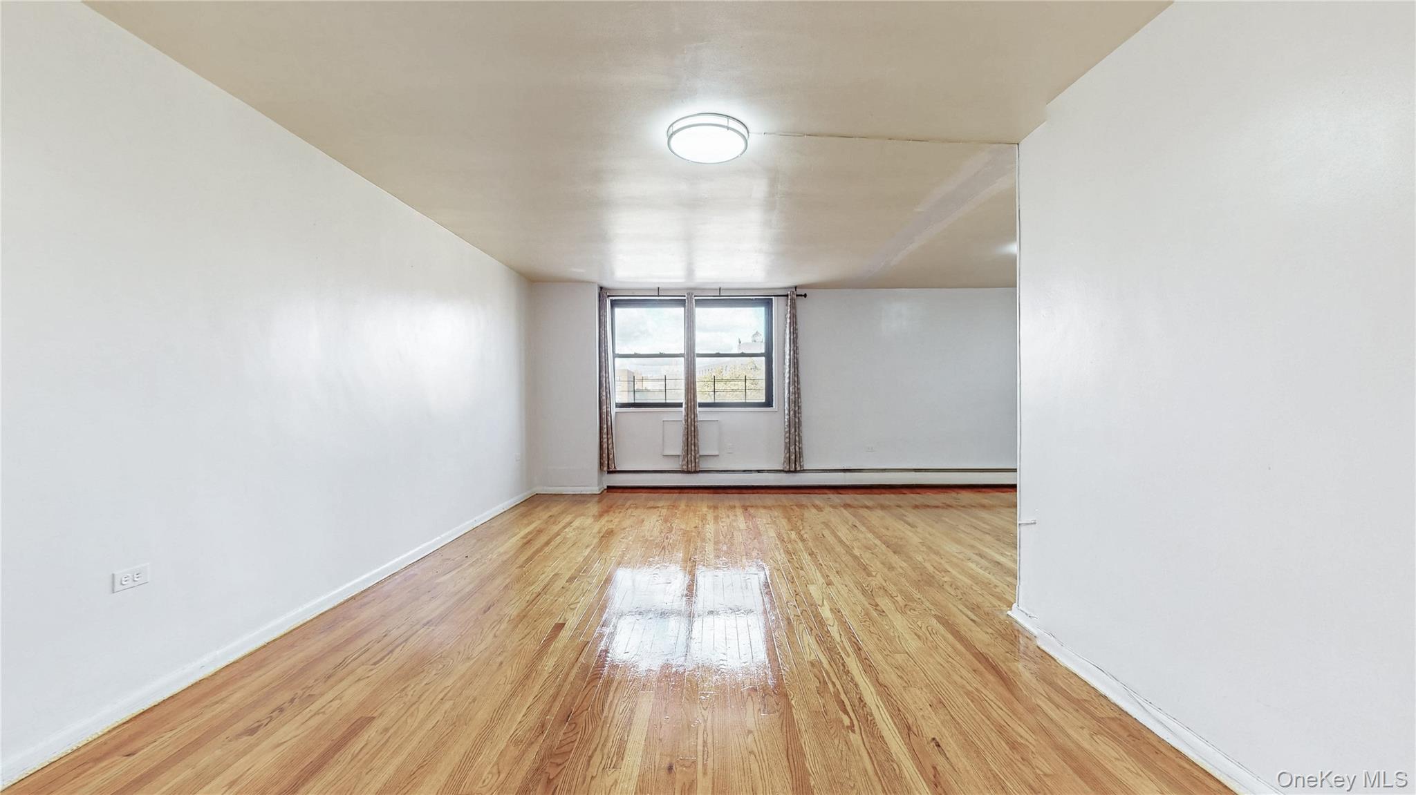 99-35 59th Avenue, Unit 4E Queens, NY 11368 - Photo 4 of 22 light woodflooring and a baseboard radiator