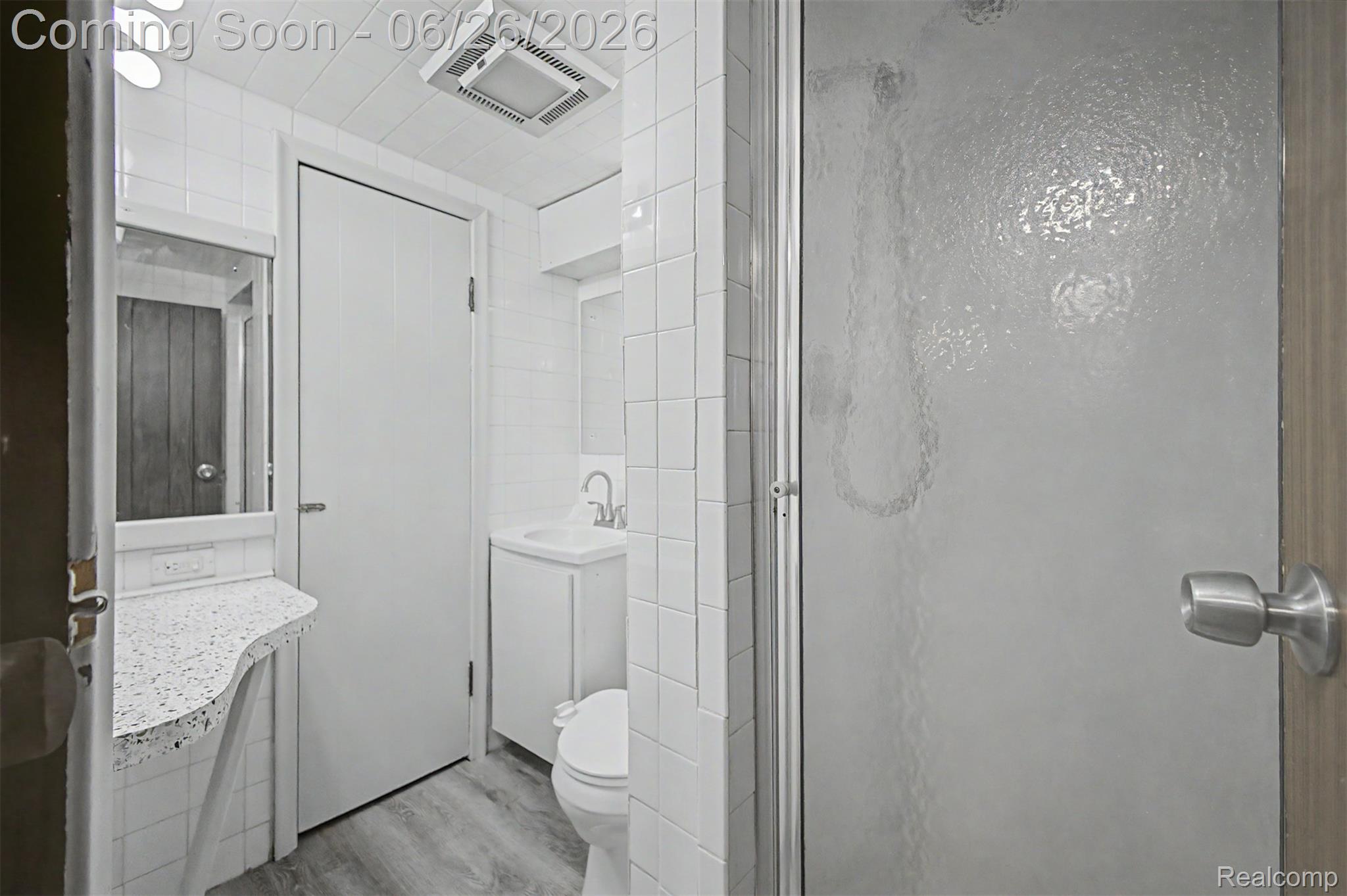 2216 Banner Street Dearborn, MI 48124 - Photo 27 of 34 Bathroom featuring white subway tile walls, wood-finish flooring, and a white vanity with a rectangular sink