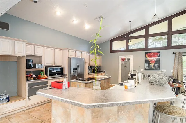 a kitchen with a refrigerator a stove a sink and cabinets