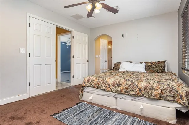 a bedroom with a bed and a mirror on a dresser