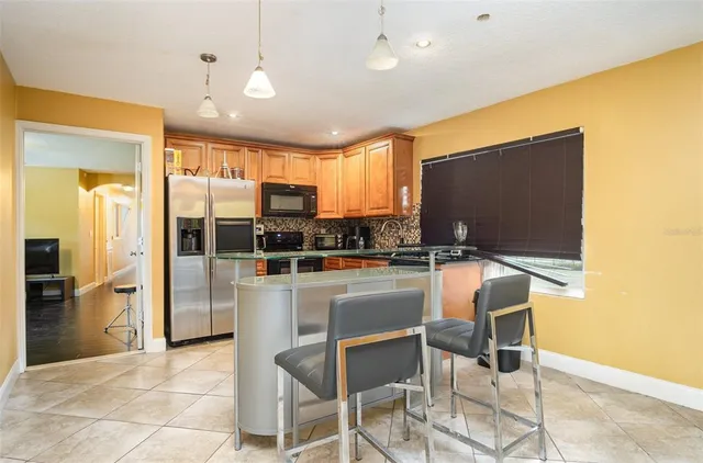a kitchen with stainless steel appliances granite countertop a sink a stove and a refrigerator
