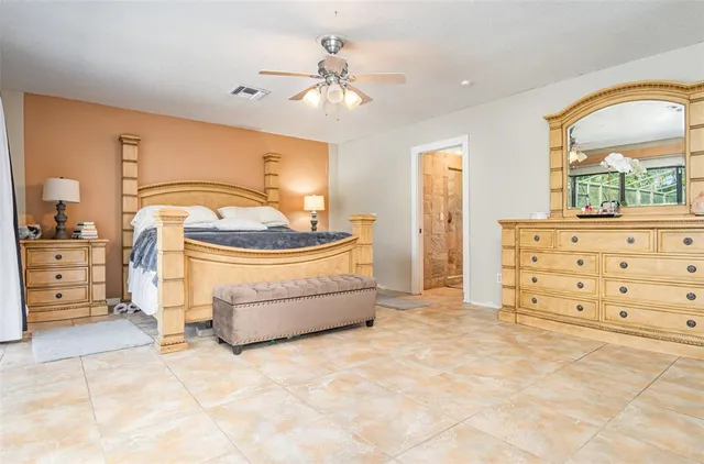 a bedroom with a bed and a lamp on dresser