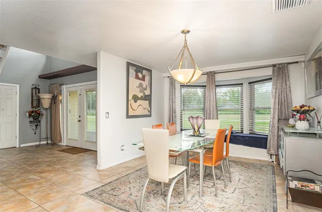 a dining room with furniture a chandelier and window