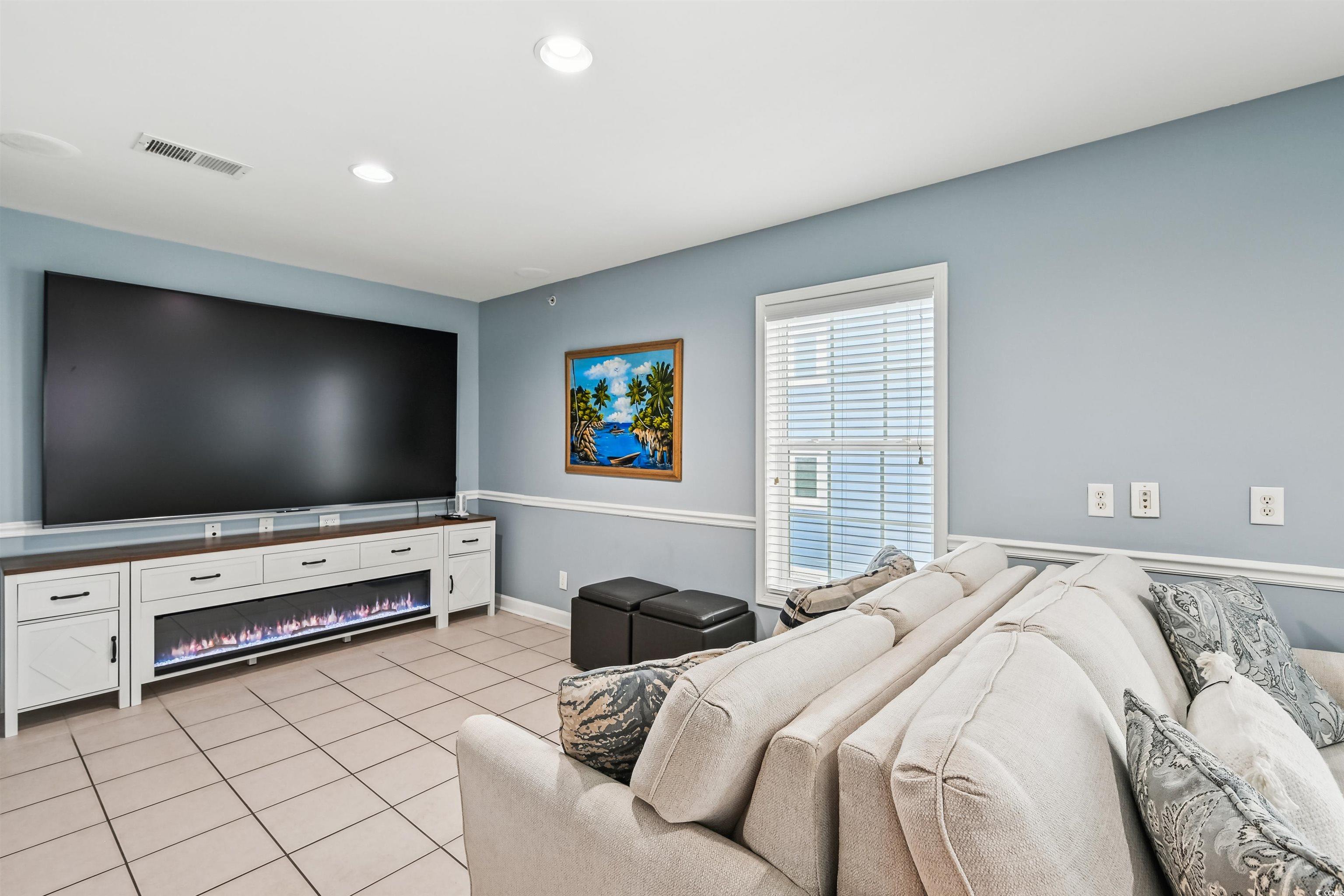 931 South Ocean Boulevard North Myrtle Beach, SC 29582 - Photo 21 of 40 Living room featuring a glass covered fireplace, light tile patterned flooring, and recessed lighting