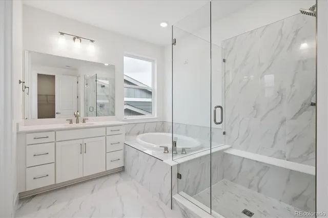 a bathroom with a tub sink shower and mirror