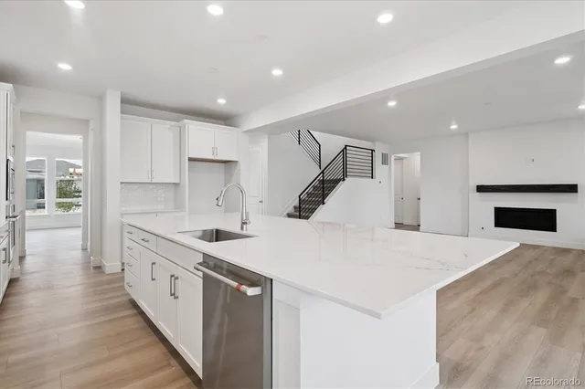 a large white kitchen with a sink and dishwasher stove