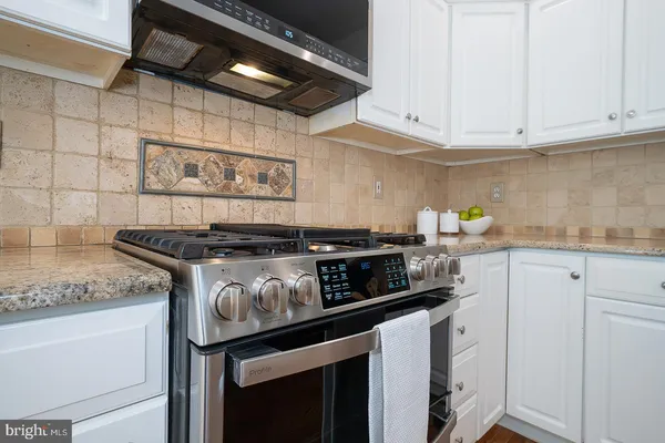 a kitchen with stainless steel appliances granite countertop a sink stove and cabinets