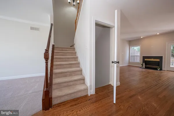a view of a livingroom with wooden floor and staircase
