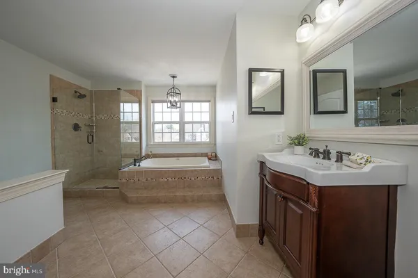 a spacious bathroom with a granite countertop sink a toilet a mirror and bathtub