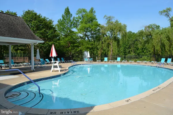 swimming pool view with a seating space and a garden view