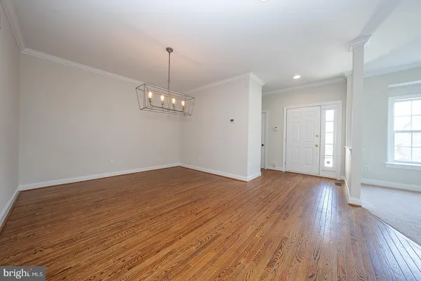 a view of empty room with wooden floor and window