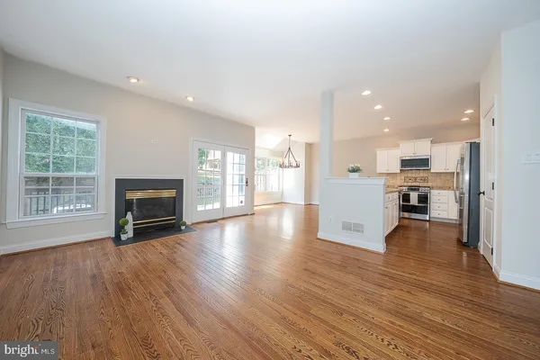 a view of a kitchen with furniture wooden floor and a fireplace
