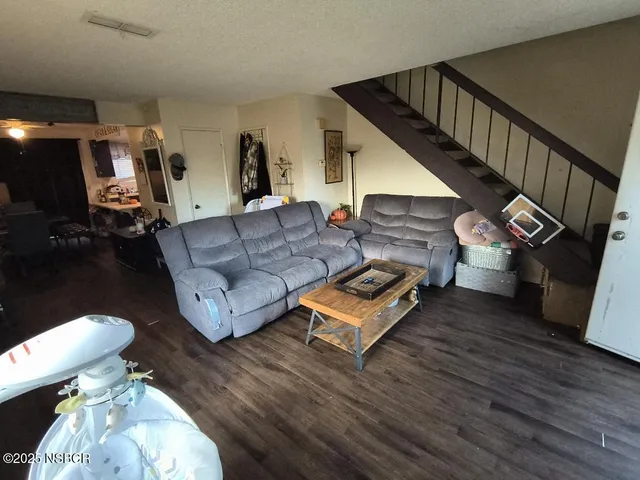 a living room with furniture and a wooden floor