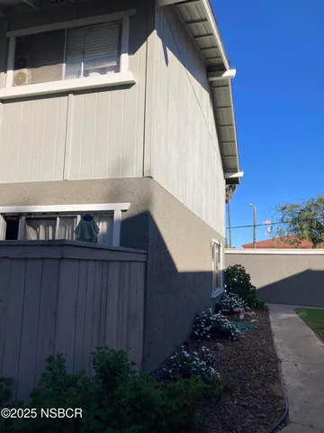 a view of a house with a yard and wooden fence