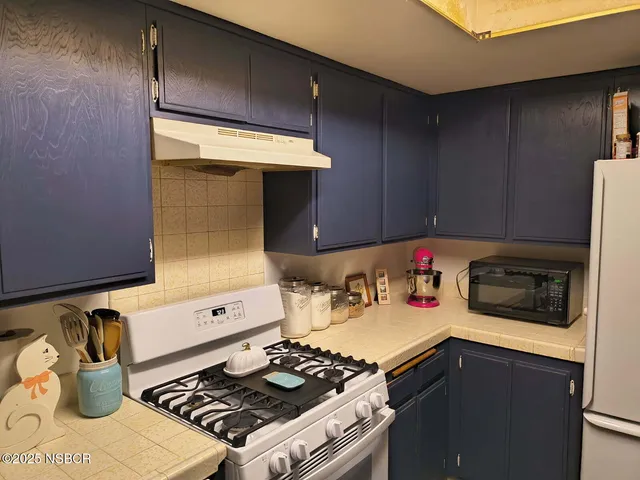 a stove top oven sitting inside of a kitchen