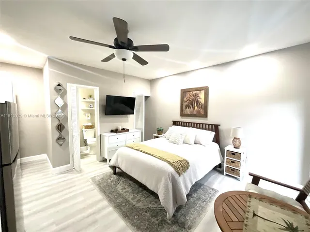 a bedroom with a bed a flat screen tv and a couch