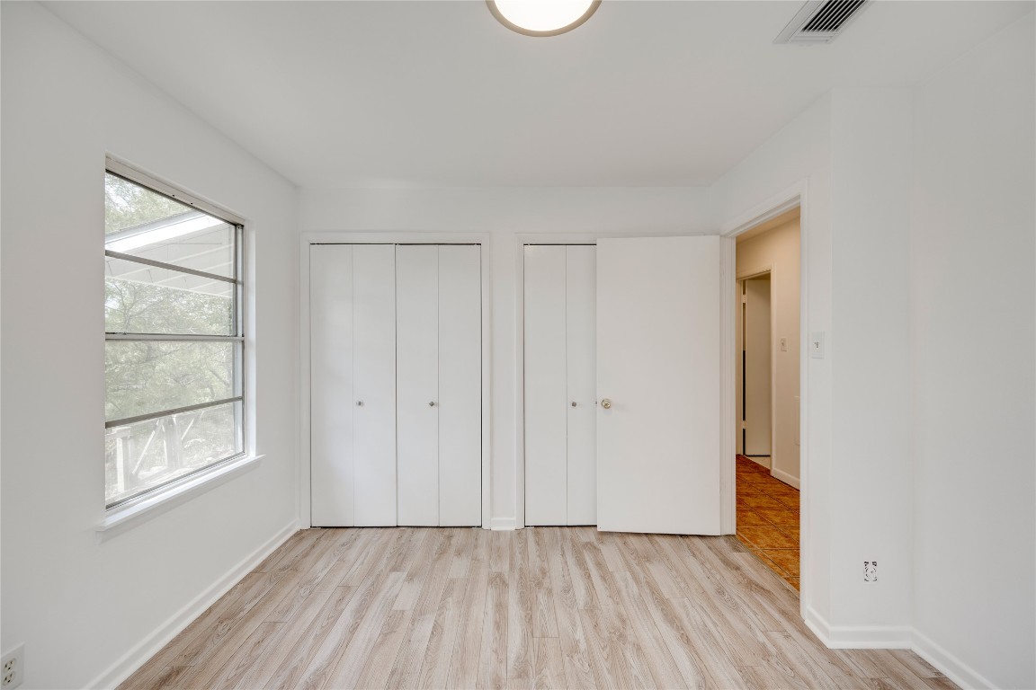 4710 Roundup Trail Austin, TX 78745 - Photo 12 of 26 a view of an empty room with window and wooden floor