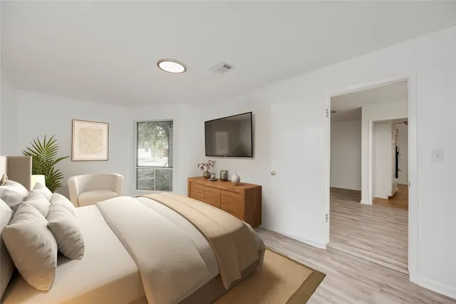 a bedroom with a bed and a flat screen tv