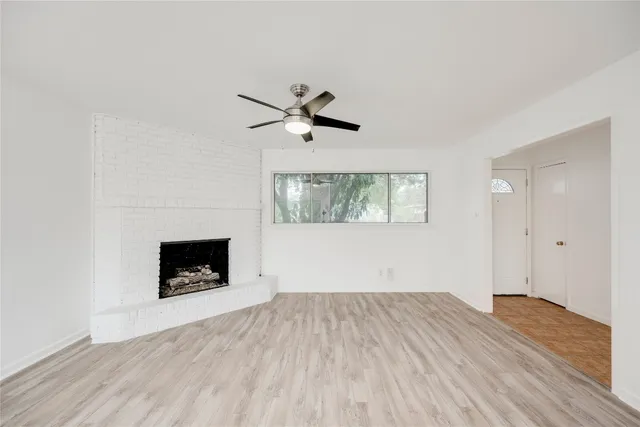 an empty room with a fireplace and wooden floor