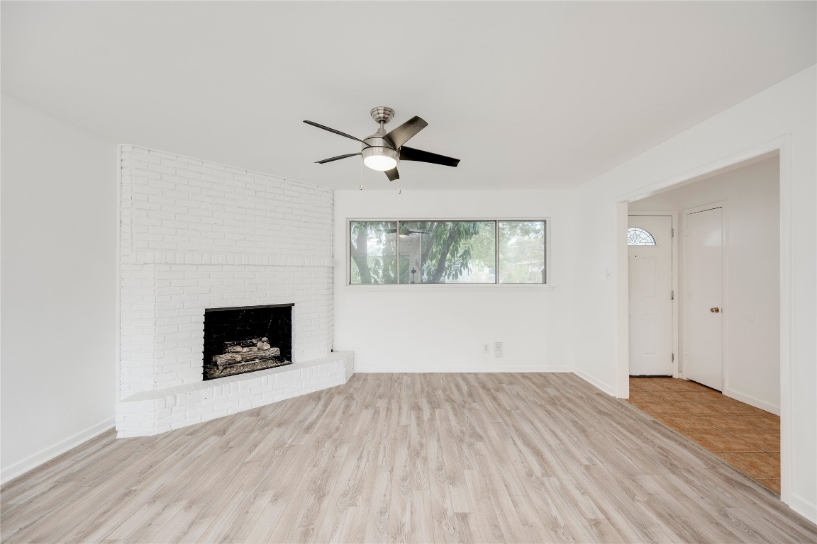 4710 Roundup Trail Austin, TX 78745 - Photo 2 of 26 an empty room with a fireplace and wooden floor