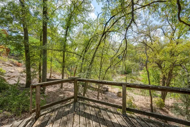 a view of a balcony with wooden floor and fence
