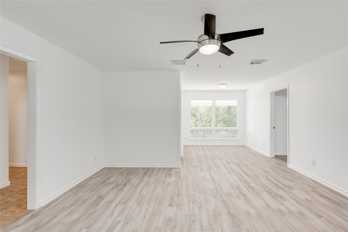 4710 Roundup Trail Austin, TX 78745 - Photo 4 of 26 an empty room with wooden floor ceiling fan and windows