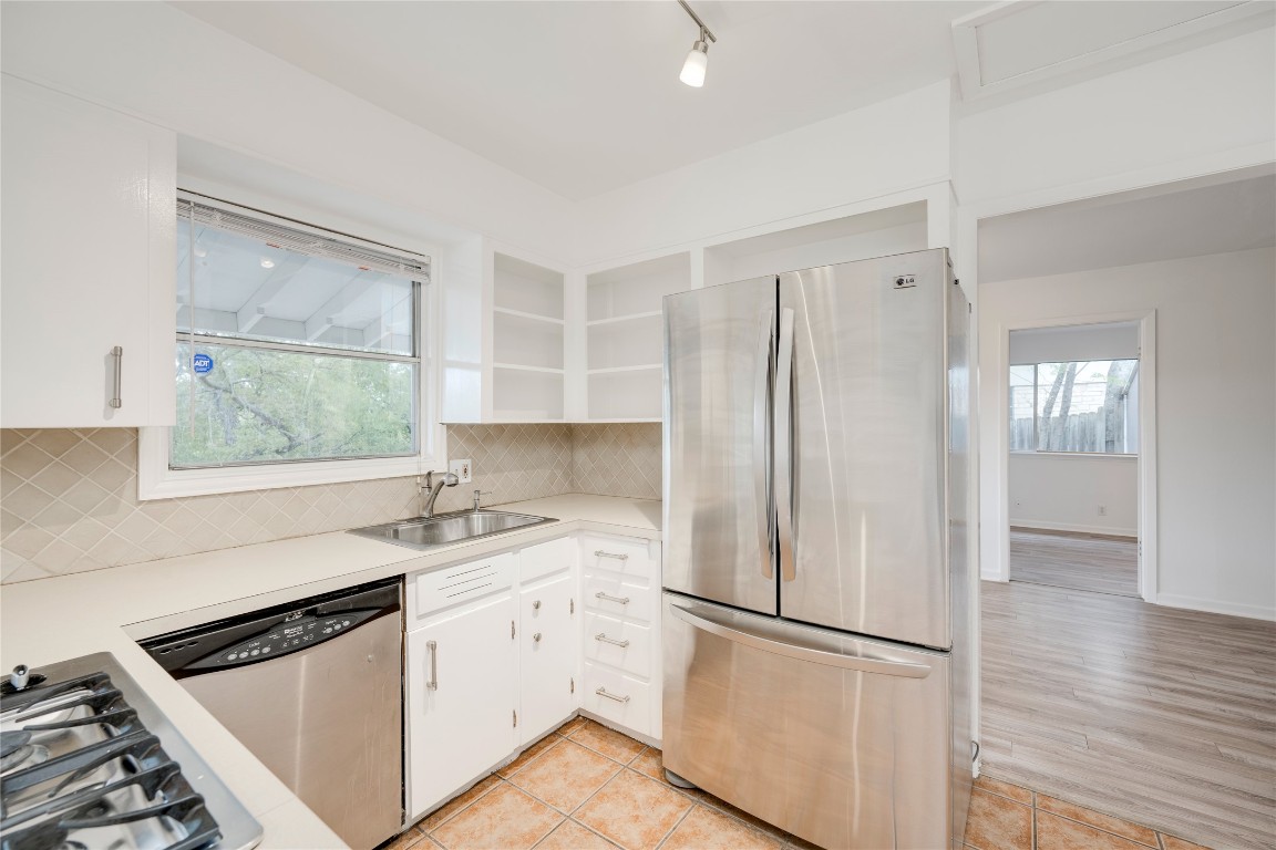 4710 Roundup Trail Austin, TX 78745 - Photo 9 of 26 a kitchen with a refrigerator a sink and wooden floor