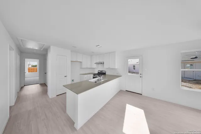 a large white room with a large mirror and sink