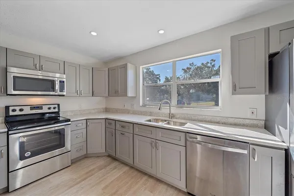 a kitchen with a sink stove and microwave