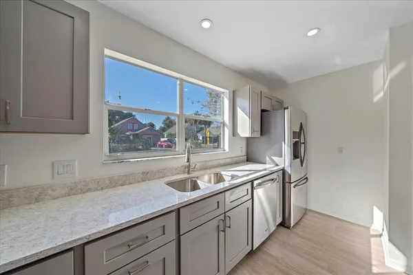 a kitchen with stainless steel appliances granite countertop a sink a stove and a refrigerator