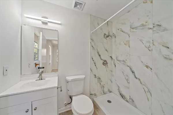 a bathroom with a toilet sink shower and mirror