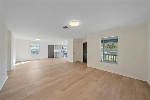 an empty room with windows and cabinet