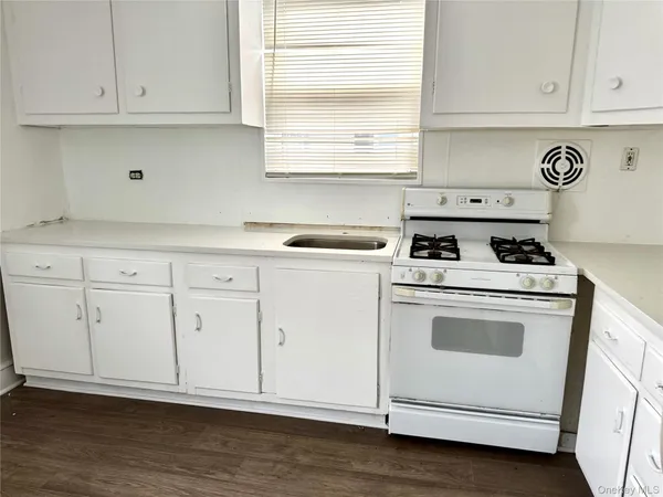 a kitchen with granite countertop white cabinets and white appliances