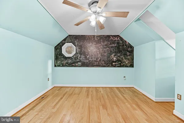 a view of a room with wooden floor and a ceiling fan