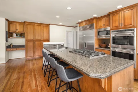 a kitchen with stainless steel appliances granite countertop a stove refrigerator and cabinets
