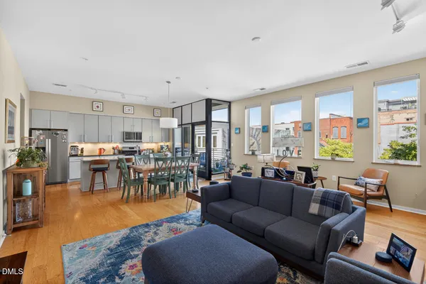 a living room with furniture wooden floor and a large window