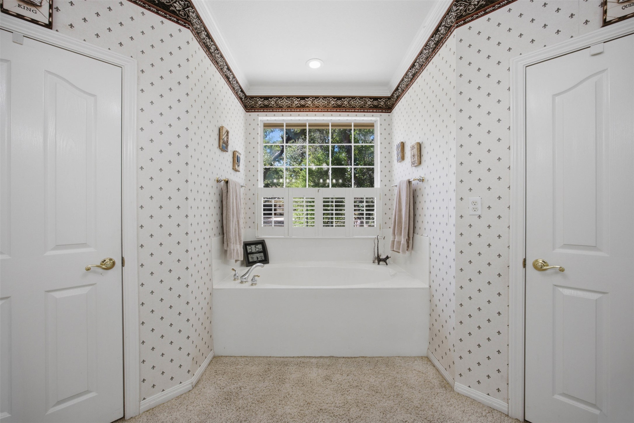197 Elm Wood Drive Elgin, TX 78621 - Photo 22 of 37 Indulge in relaxation with this serene bathroom, featuring a deep soaking tub beneath a sun-filled window, flanked by convenient access points.