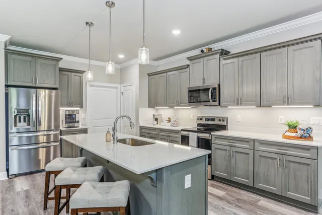 a kitchen with stainless steel appliances granite countertop a sink a stove and a refrigerator