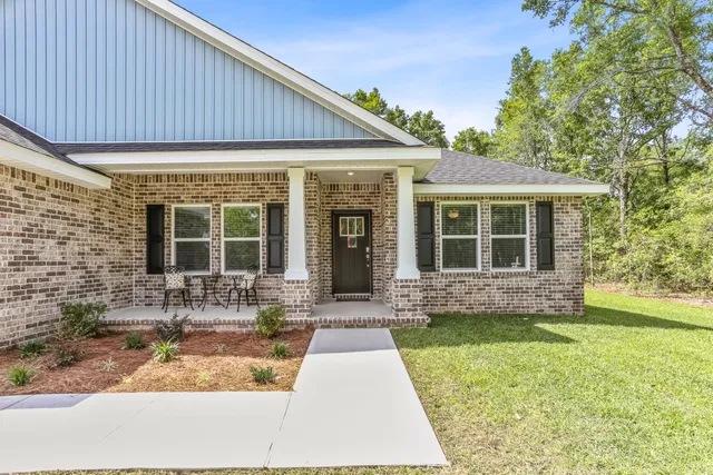a front view of a house with a garden and patio